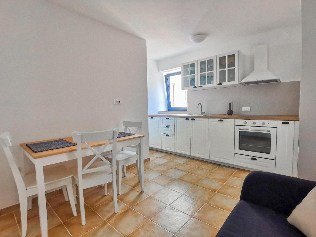 a kitchen with a table and a table and chairs at Apartment Muretto in Bašanija