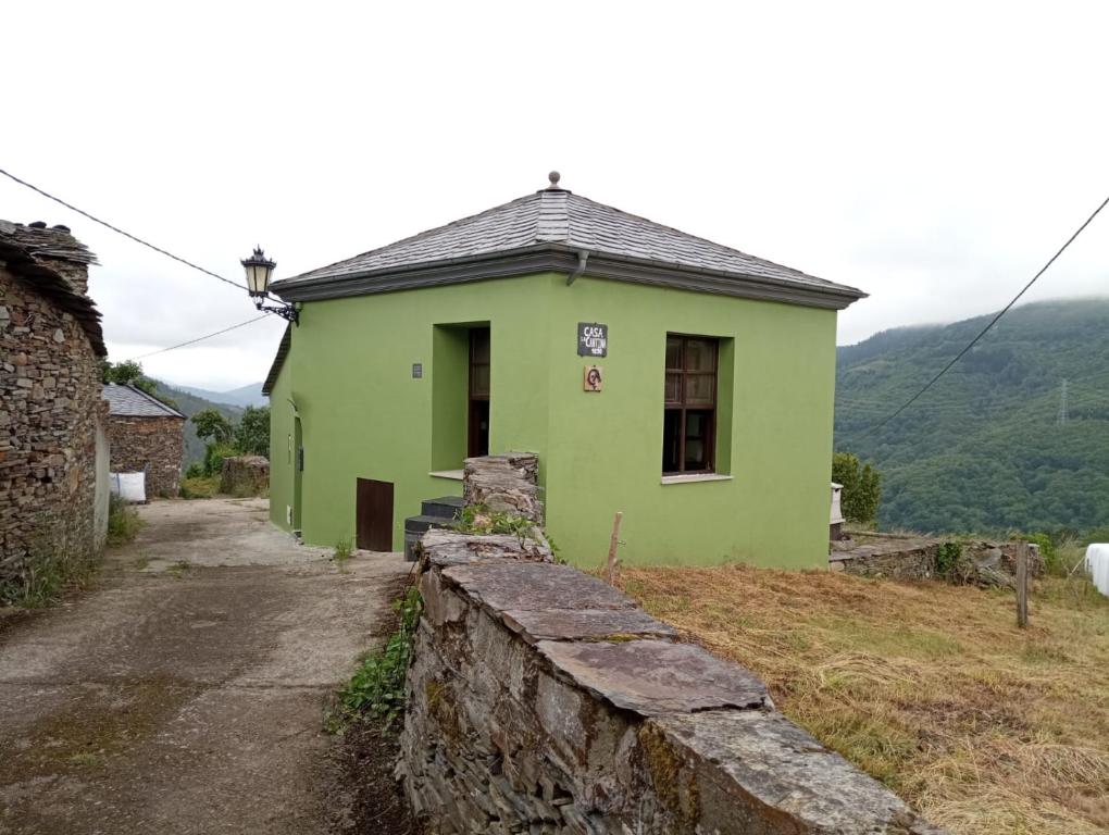een groen huis bovenop een heuvel bij Casa Rural de alquiler integro La Cantina de Villarmayor-Asturias in Villarmayor