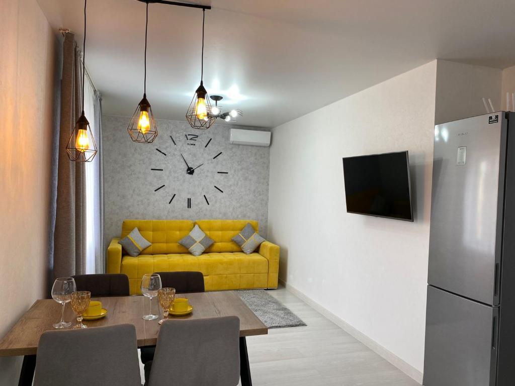 comedor con mesa y sofá amarillo en VIP апартаменты на Жукова en Oral