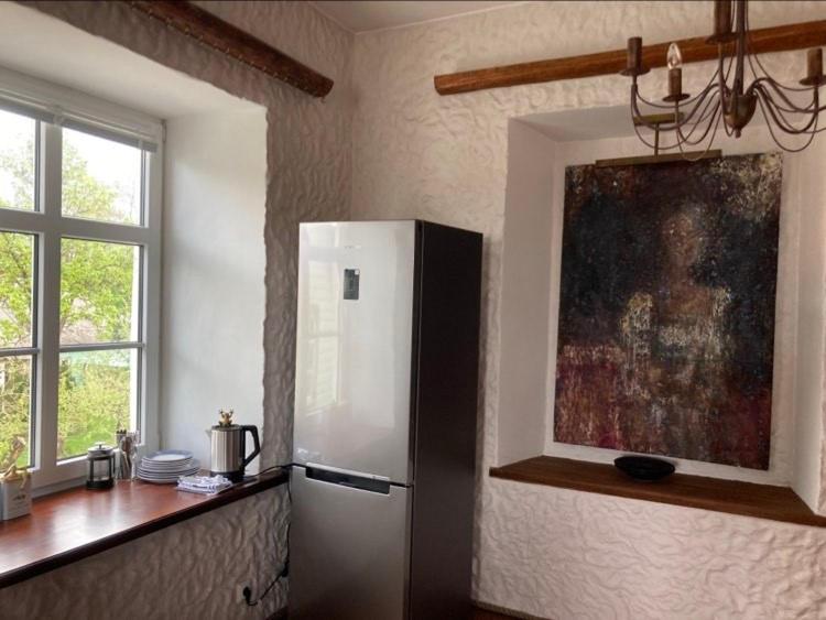 een keuken met een koelkast en een schilderij aan de muur bij Saue 10 in Haapsalu