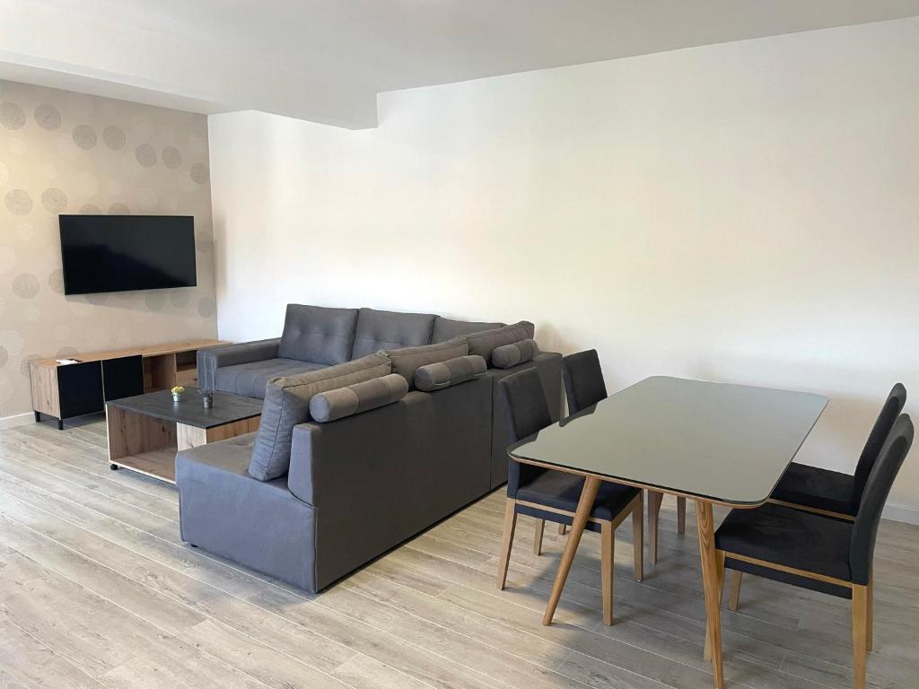 uma sala de estar com um sofá e uma mesa em Apartman Jure em Široki Brijeg
