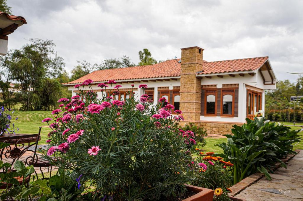 une maison avec des fleurs devant elle dans l'établissement Casa de las Flores- Chalet Privado, à Villa de Leyva