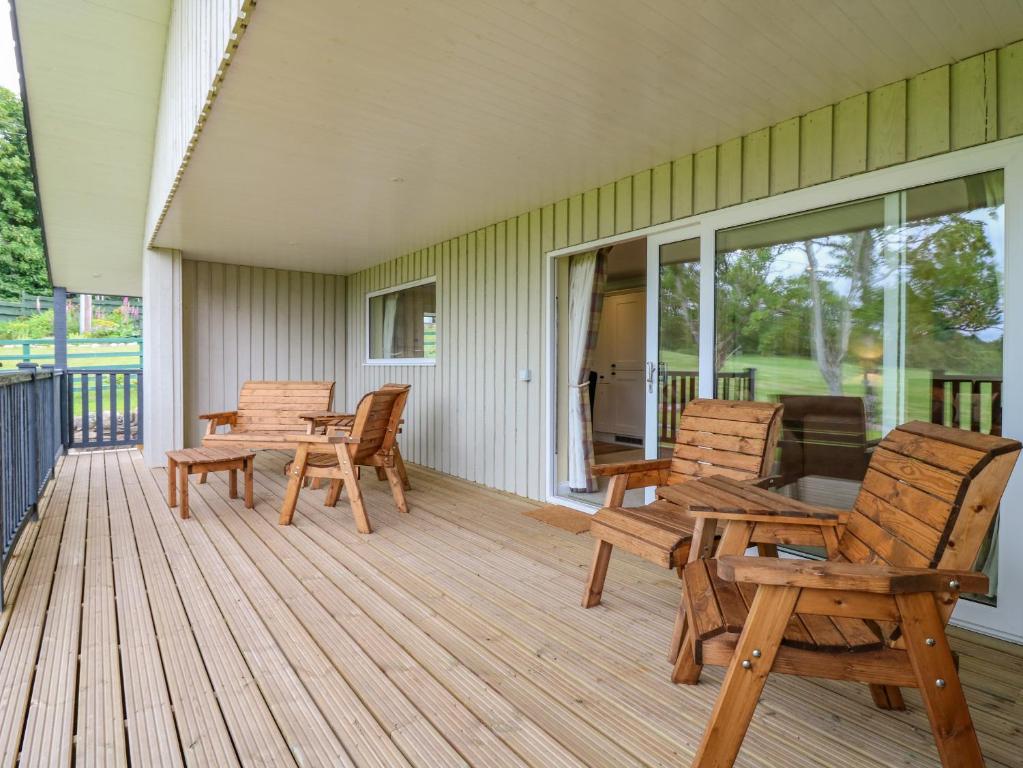 a deck with chairs and tables on a house at The Lodge in Blairgowrie