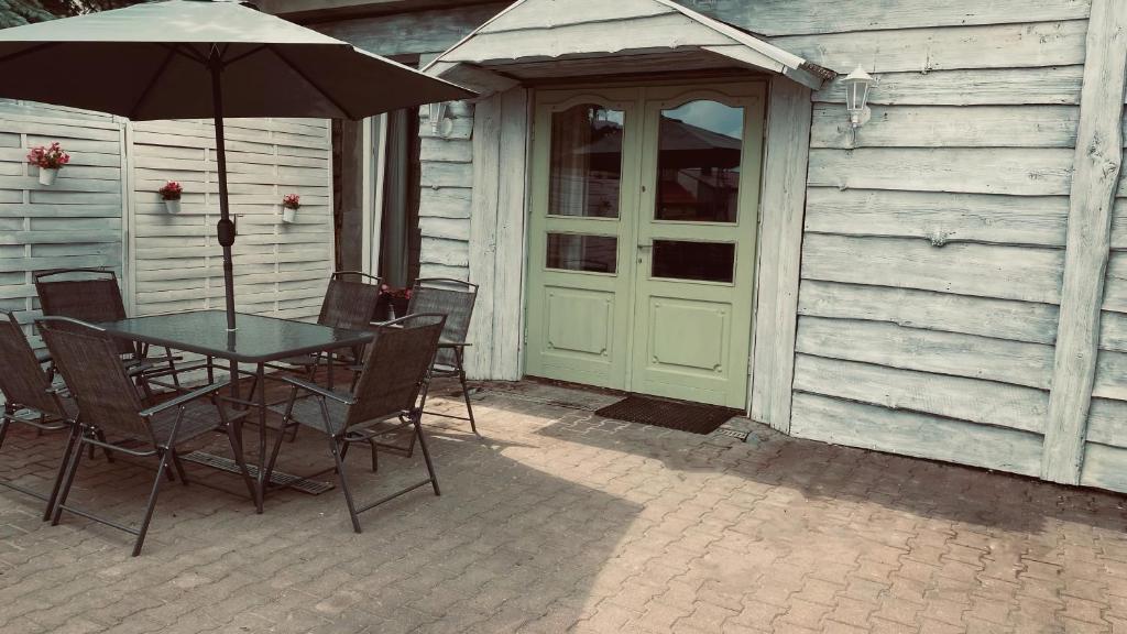 un tavolo e sedie con un ombrellone in un patio di Apartament Vintage a Mrągowo