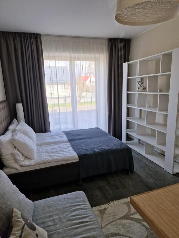 een slaapkamer met een bed en een groot raam bij Aisa 39 Apartment in Pärnu