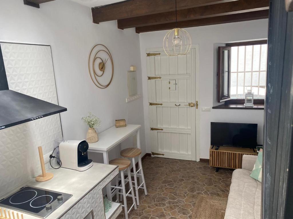 a kitchen with a stove and a living room at Casa Arequipa in Vejer de la Frontera