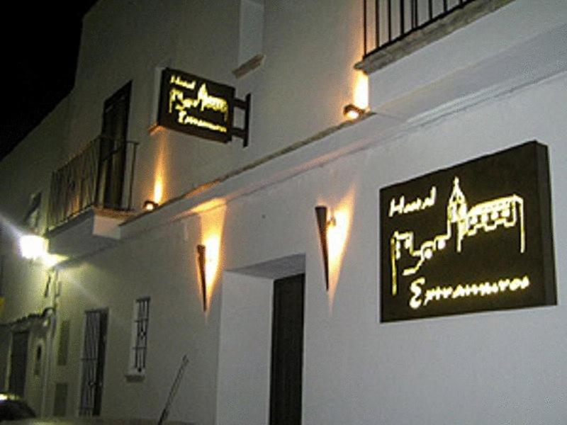 a white building with signs on the side of it at Hostal Extramuros in Conil de la Frontera