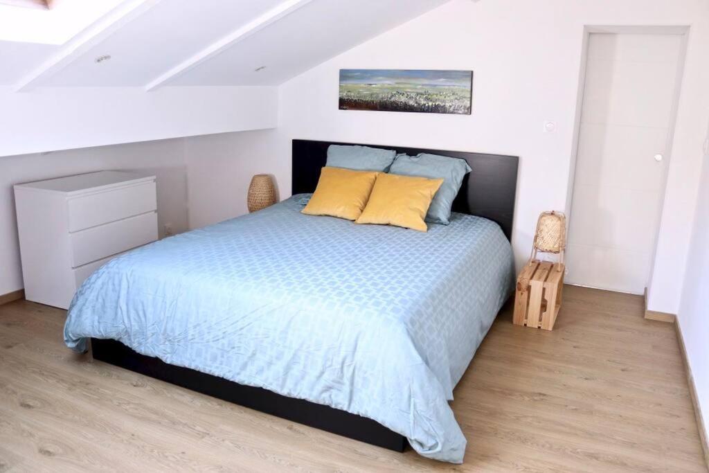 um quarto com uma cama grande e almofadas amarelas em Margarita Apt Climatisé T2 4 pers Centre parking em Le Touquet-Paris-Plage