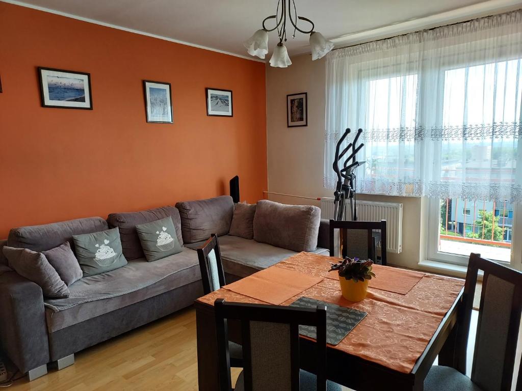 a living room with a couch and a table at Cozy Rooms Gdańsk in Gdańsk
