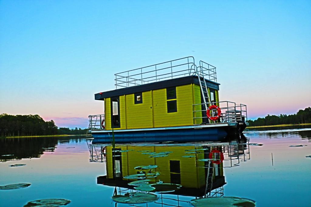 a yellow boat in the middle of a lake at AQUA Bērzgale in Bērzgale