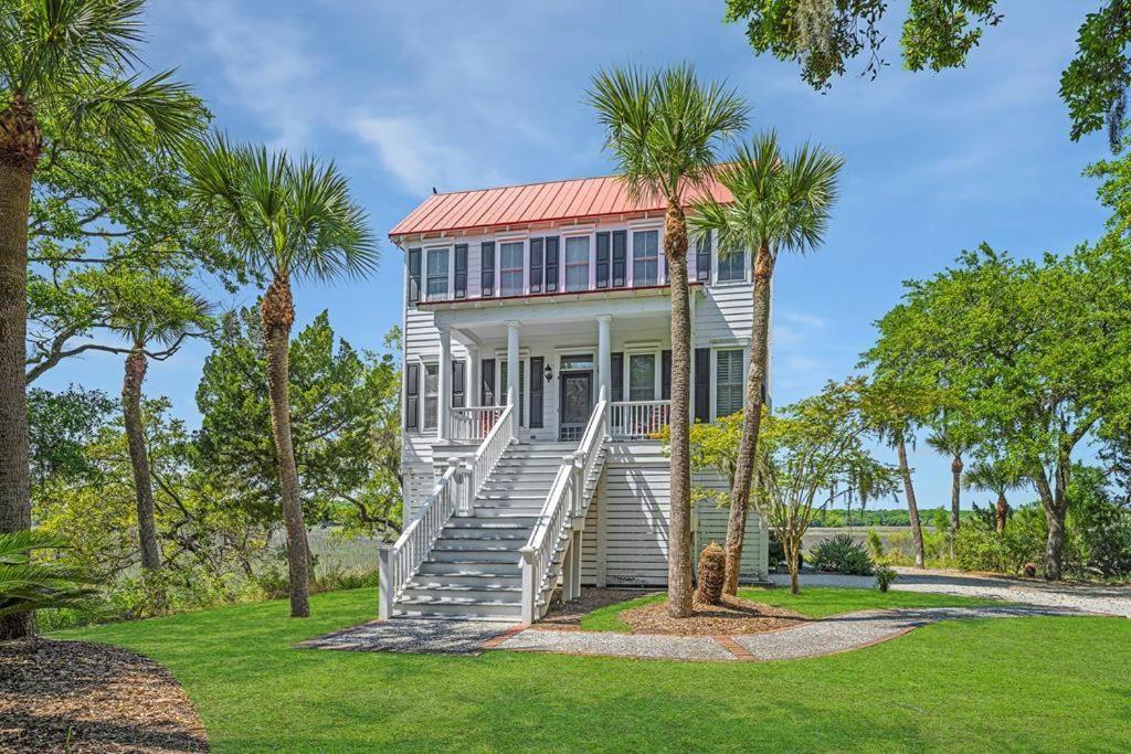 a white house with a red roof with palm trees at Marsh Mellow in Edisto Island