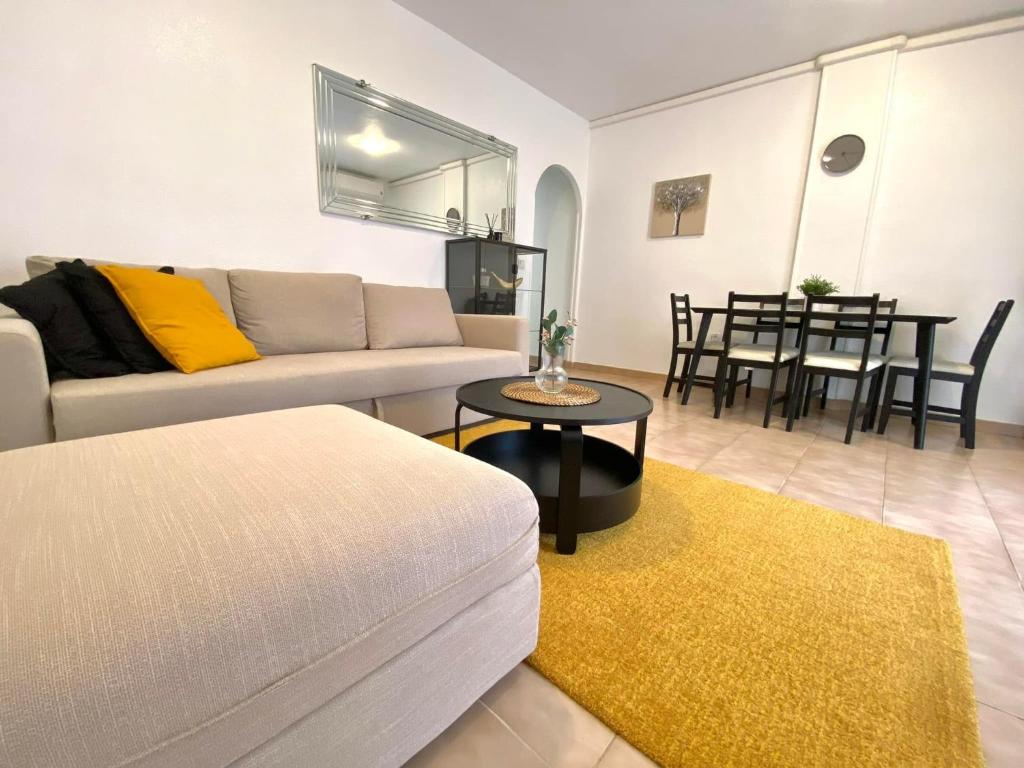 ein Wohnzimmer mit einem Sofa und einem Tisch in der Unterkunft Locos Beach Holiday Apartments in Torrevieja