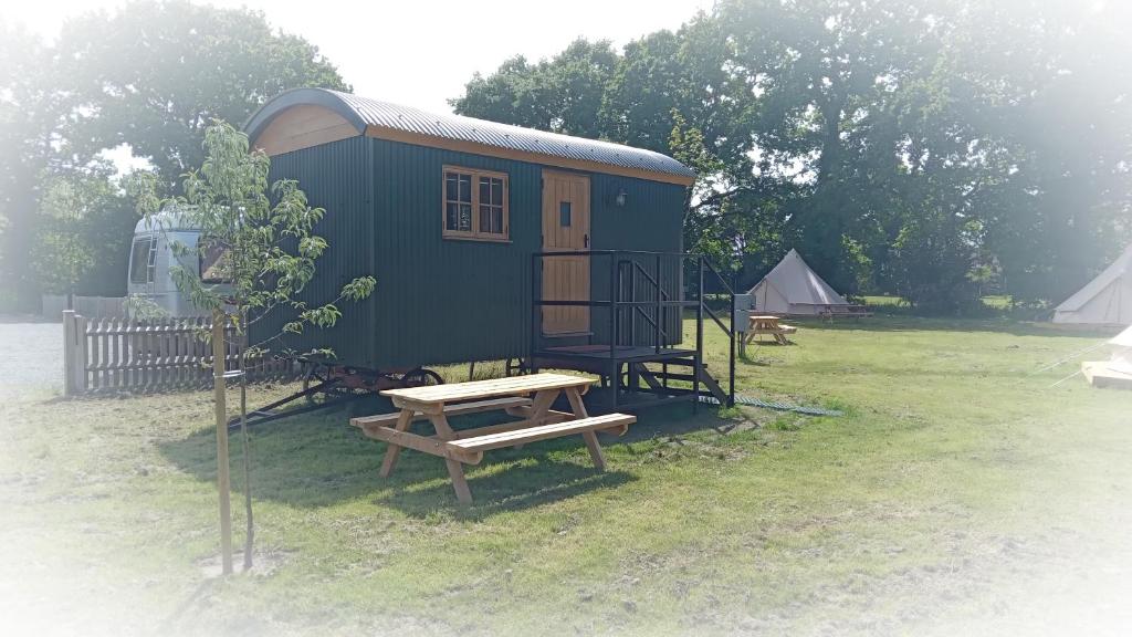 a tiny house with a picnic table and a bench at The Homestead in West Parley