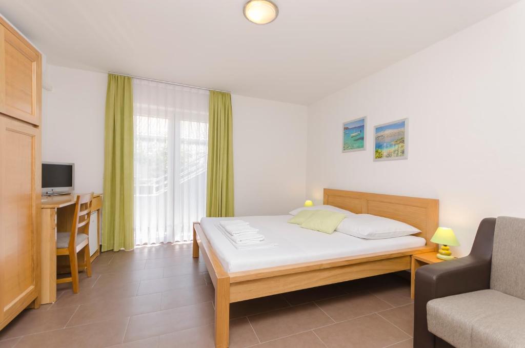 a bedroom with a bed and a desk and a couch at Zimmer Katarina in Vodice