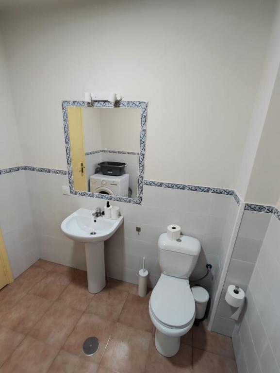 łazienka z toaletą, umywalką i lustrem w obiekcie Apartamento Bajamar w mieście El Puerto de Santa María
