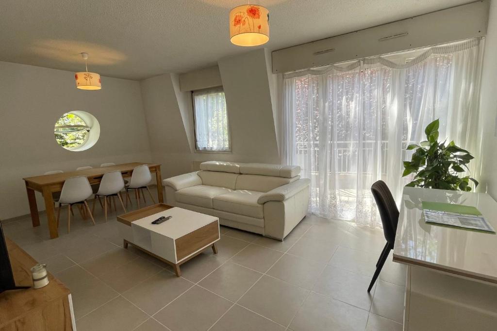 a living room with a couch and a table at Le Bois Gentil - Grand appartement familial, proche de Genève et du Palexpo in Saint-Julien-en-Genevois