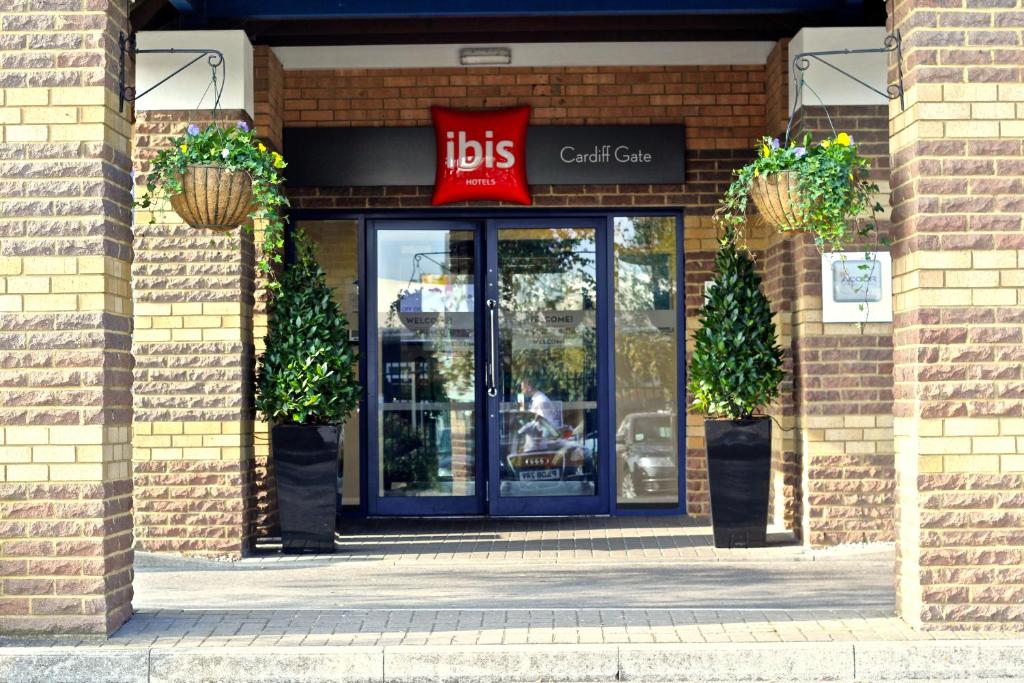 przednia część sklepu z niebieskimi drzwiami i znakiem w obiekcie ibis Cardiff Gate - International Business Park w Cardiff