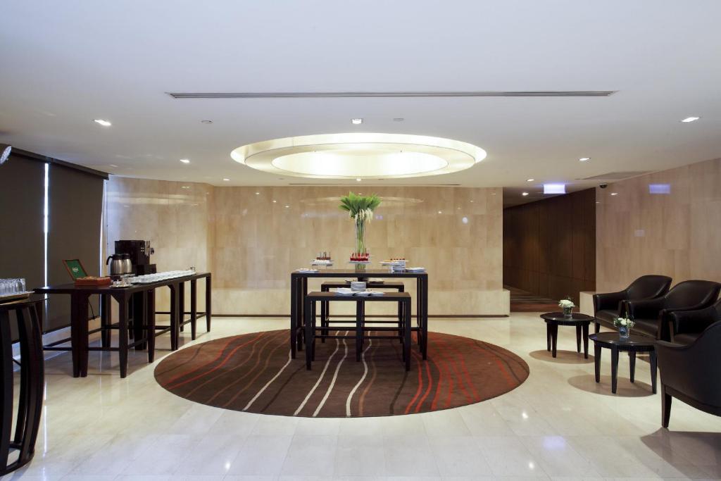 A polished waiting area with armchairs, refreshments and a central floral display.