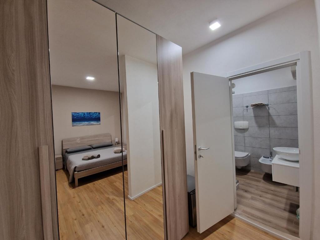 bagno con porta a vetri che conduce a una camera da letto di The Shell Guest House ad Alghero