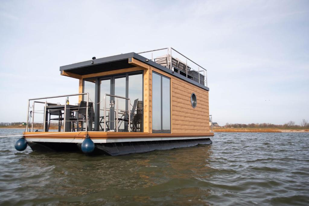 a houseboat is sitting in the water at Maasbootje in Kinrooi