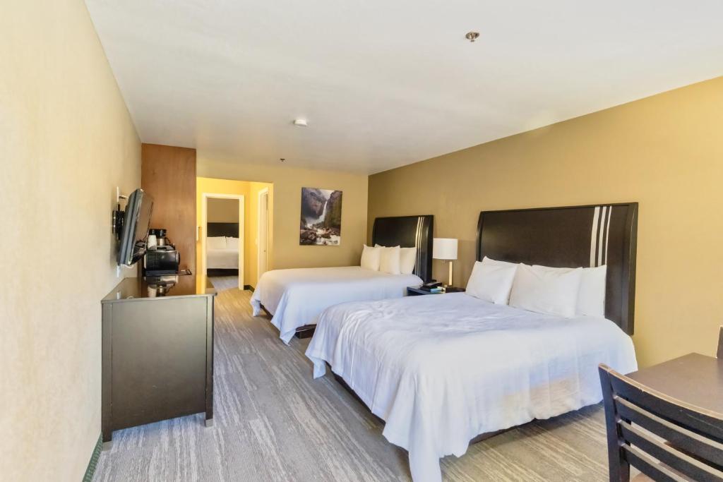 奧克赫斯特的住宿－The Oakhurst Inn at Yosemite，酒店客房设有两张床和电视。