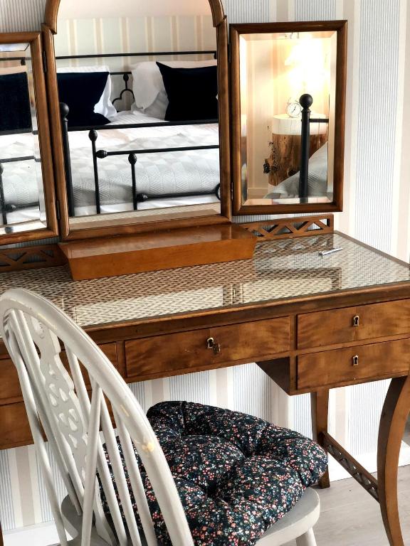 a desk with two mirrors and a bed in a room at Goose Home and Garden in Łeba