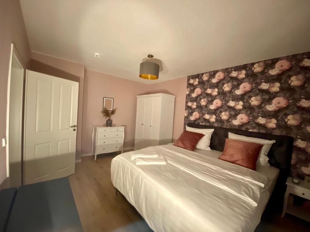 um quarto com uma cama grande e uma parede floral em Appartment Anna-Louise em Sondershausen