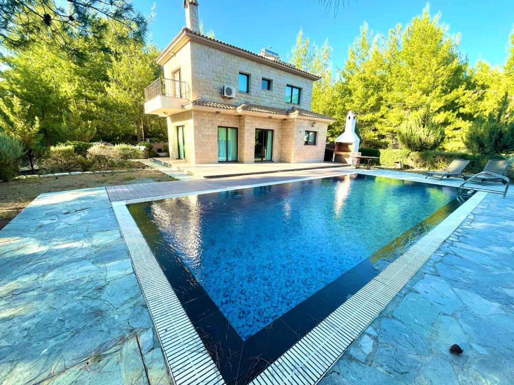 an image of a swimming pool in front of a house at Irinas country home! in Trimiklini
