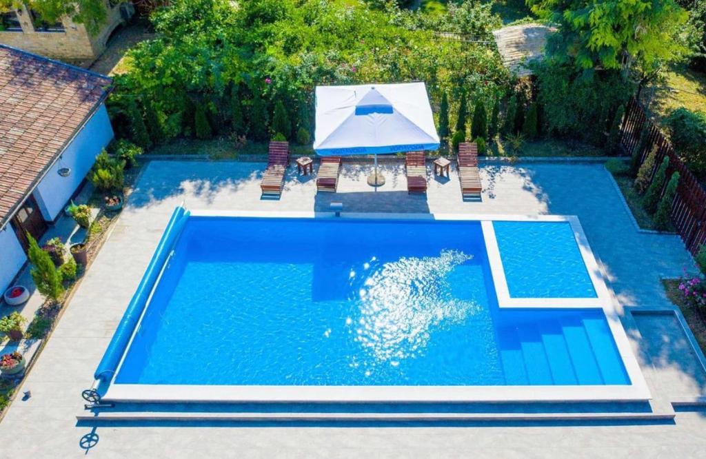 an overhead view of a swimming pool with an umbrella and chairs at Salaš Đorđević in Subotica