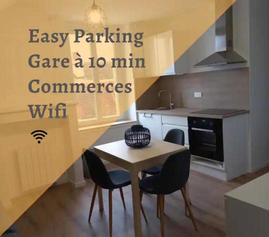 a kitchen with a table and chairs in a kitchen at Le Montjoux, appartement calme, toutes commodités in Besançon