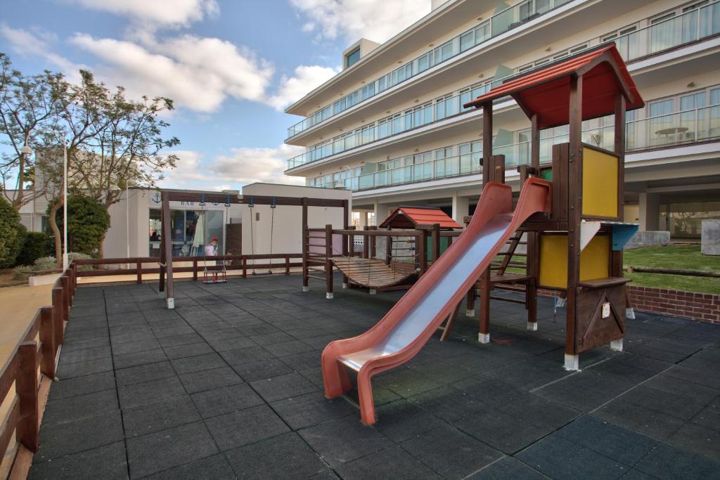 a playground with a slide in front of a building at Marina Club Lagos Resort in Lagos