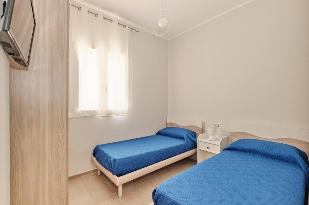 sypialnia z dwoma łóżkami i oknem w obiekcie La Maison De Lulu w mieście Gallipoli