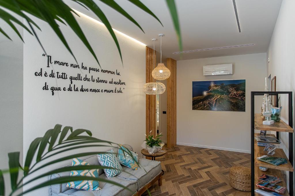 a living room with a couch and a poster on the wall at Brezza Marina Guest House in Porto Ercole
