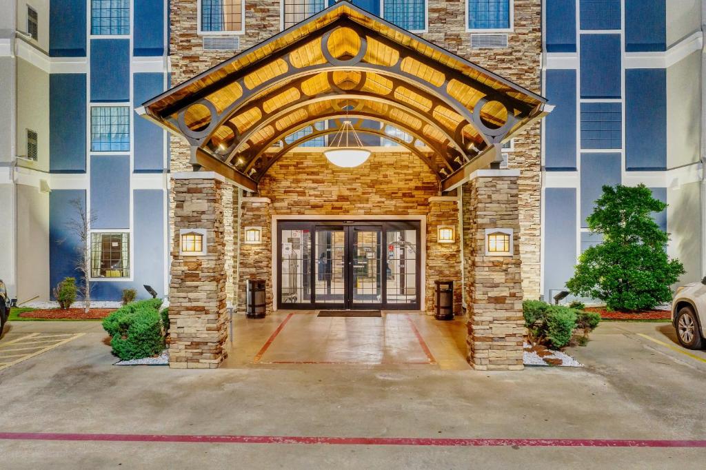 a front door of a building with a brick wall at Staybridge Suites Tyler University Area, an IHG Hotel in Tyler