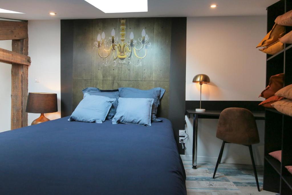 une chambre avec un lit, un bureau et un lustre dans l'établissement Le Classy, T3 hypercentre chic et cosy, Wifi par SOVALFI, à Saint-Étienne