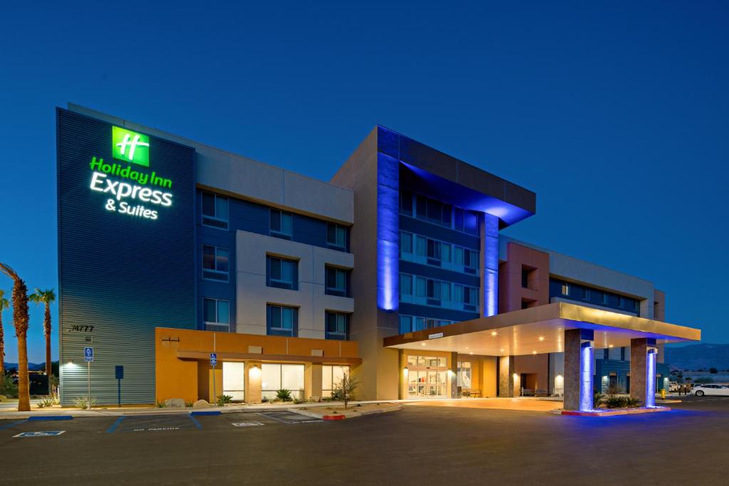 Holiday Inn Express & Suites Palm Desert - Millennium, an IHG Hotel في بالم ديزرت: مبنى مكتب مع لوحة مكتوب عليها مصاريف المستشفى والتوفير