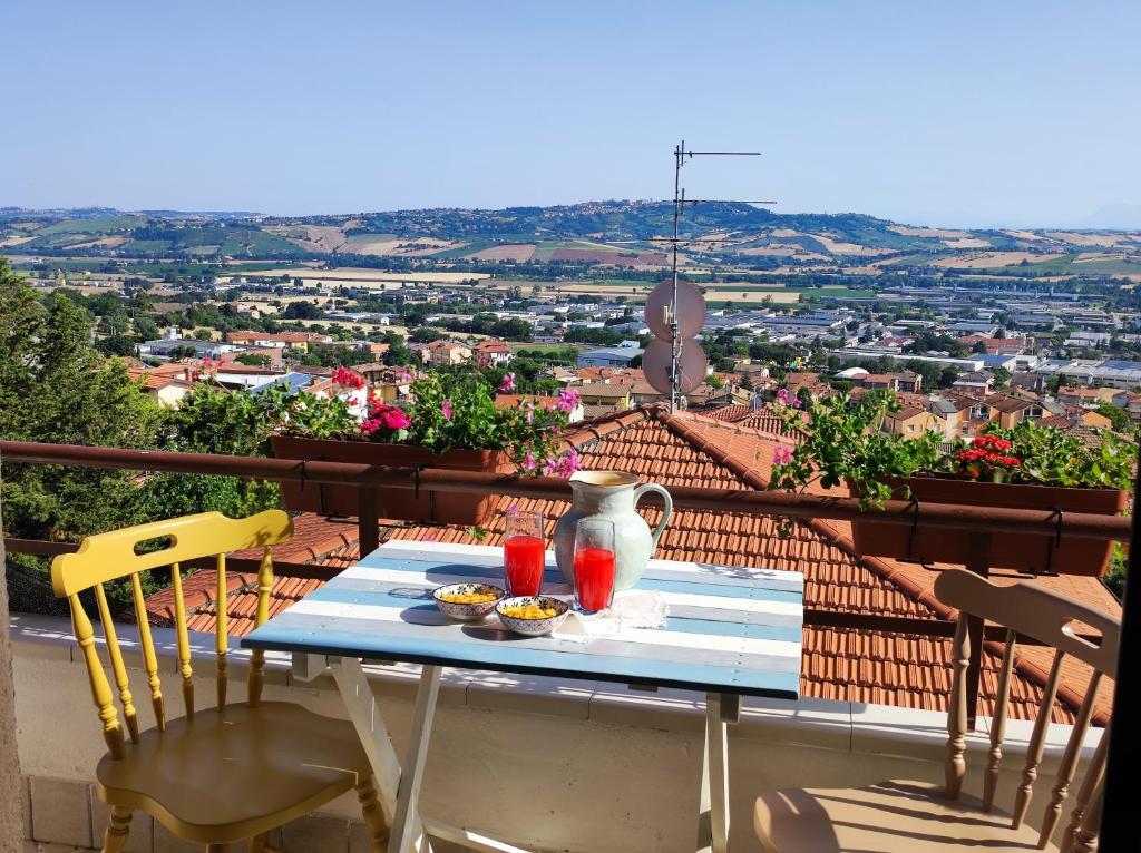 einen Tisch mit Vase und Getränken auf dem Balkon in der Unterkunft Camere Infinity Rooms in Castelfidardo