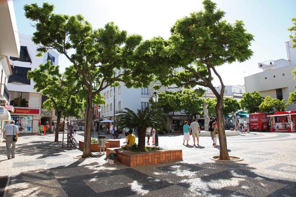 a group of people walking down a street with trees at Marina Club Lagos Resort in Lagos