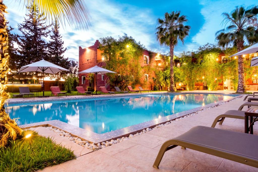 a swimming pool in front of a house at Palace Africa - Marrakech Palmeraie Retreat with Heated Pool from 01 Nov to 30 Apr in Marrakech