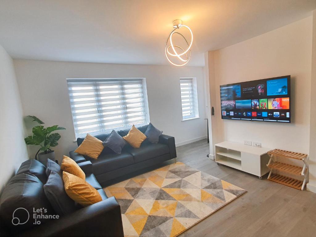 a living room with a couch and a flat screen tv at Lovely home close to City Center & Rail Station in Chesterfield