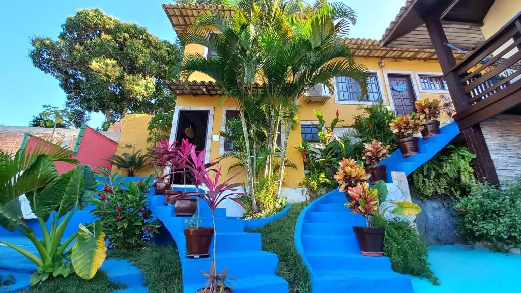 a garden in front of a house with blue pathways at Flats Tartaruga Búzios in Búzios
