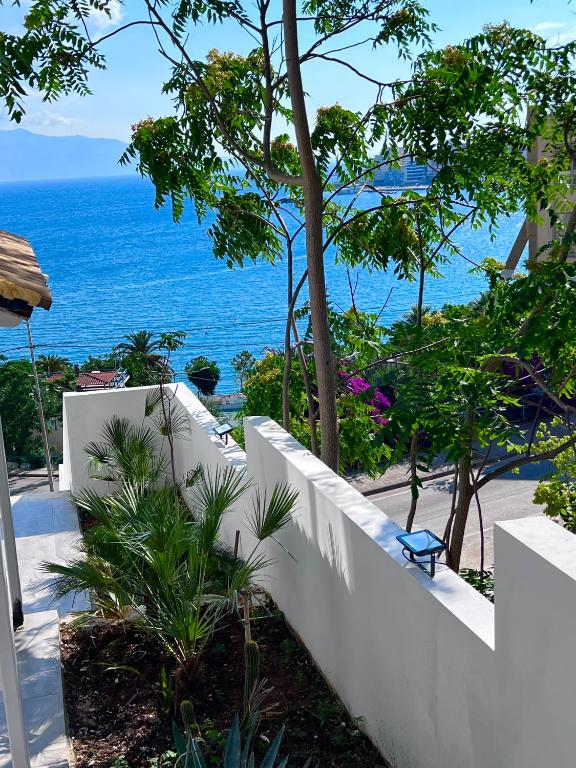 a white fence with the ocean in the background at Kanes Boutique Hotel in Sarandë
