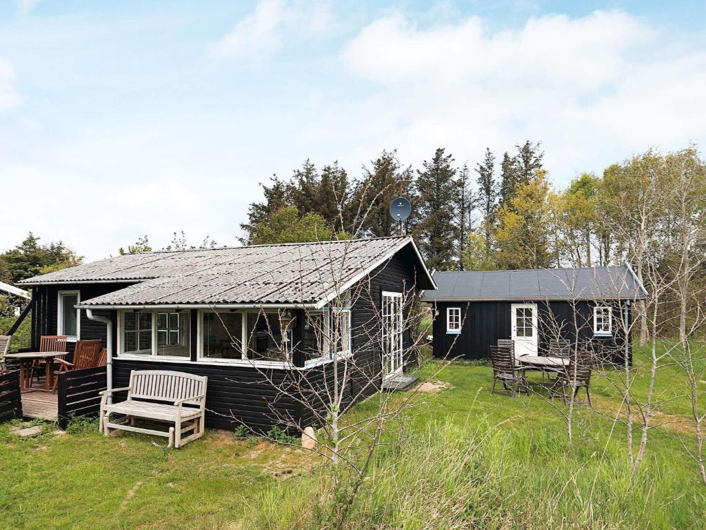 een zwart huis met een tafel en stoelen in een tuin bij 6 person holiday home in Bindslev in Bindslev