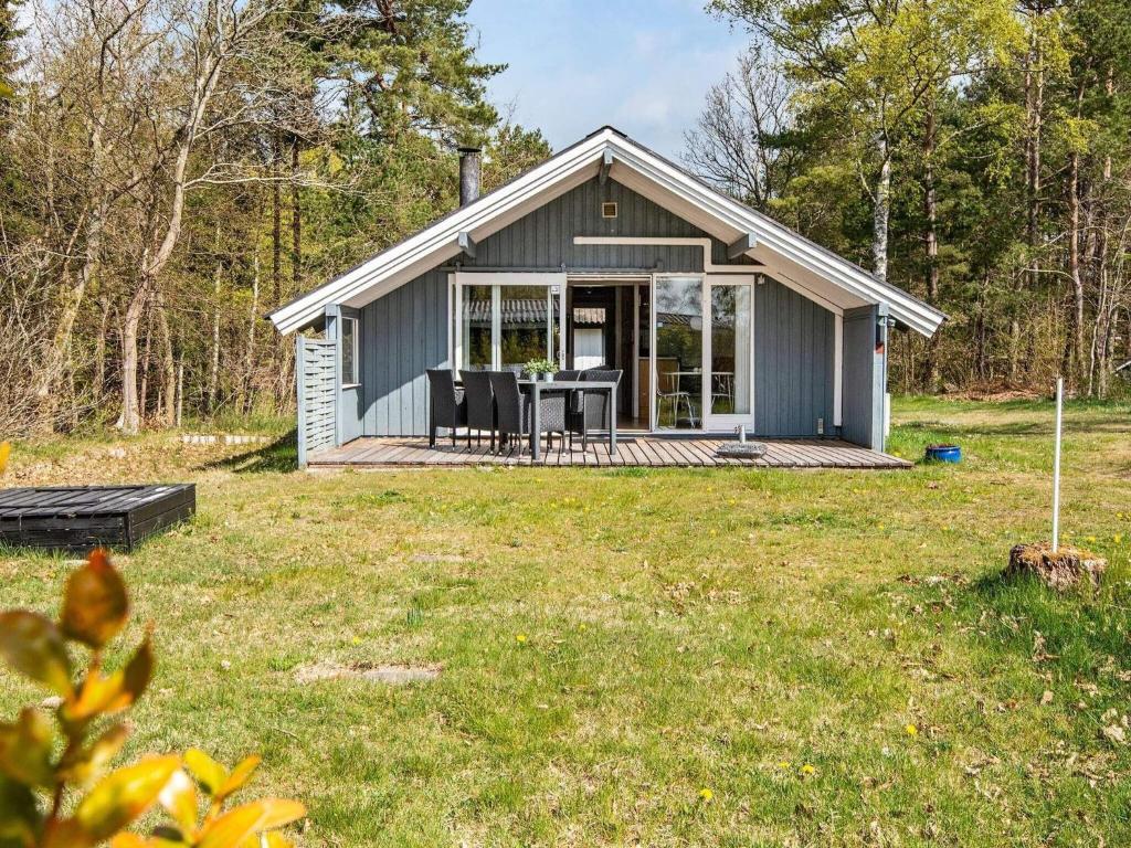 un piccolo cottage grigio con portico e tavolo di 6 person holiday home in Ebeltoft a Ebeltoft