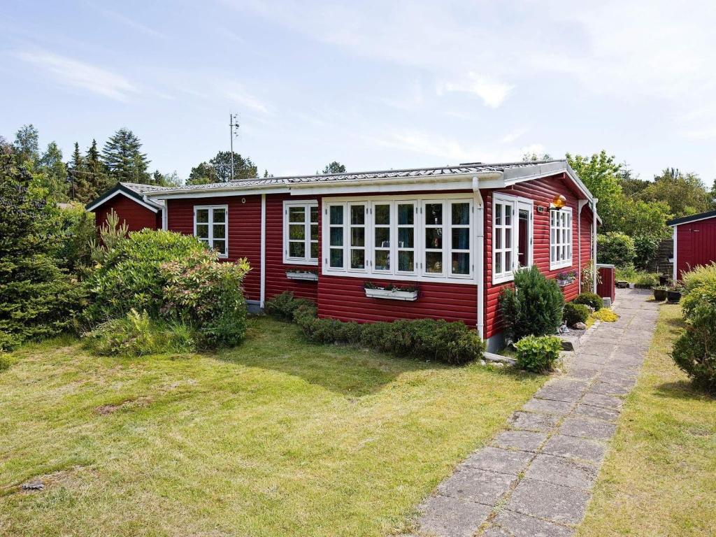 a small red house with a garden in front of it at Two-Bedroom Holiday home in Vig 2 in Vig