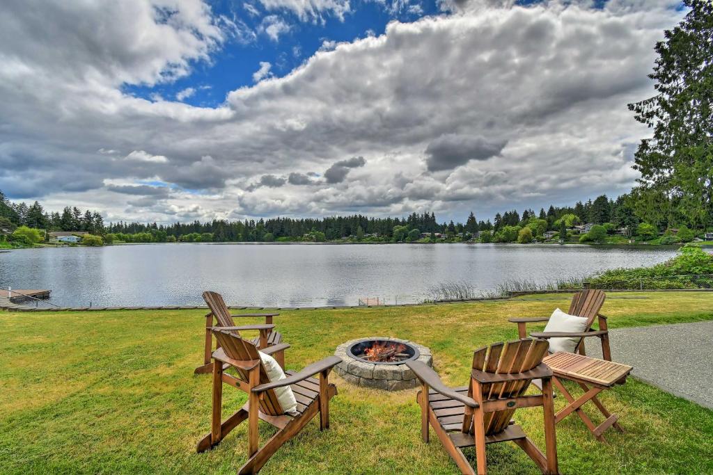 three chairs and a fire pit next to a lake at Stylish Olympia Home with Private Boat Dock! in Olympia