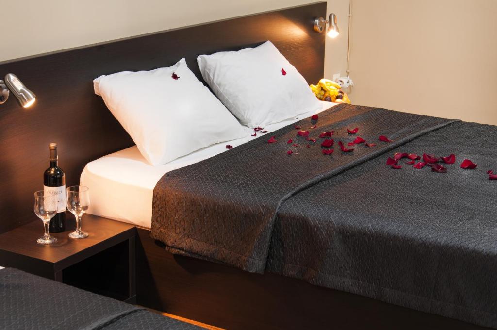 a bedroom with a bed with red roses on it at Family Hotel Pautalia in Sandanski
