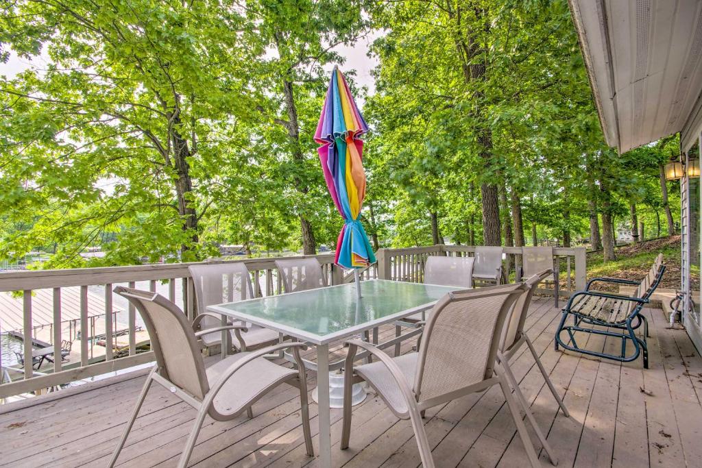 una mesa con sillas y una sombrilla en una terraza en Waterfront Lake of the Ozarks Home with Views!, en Gravois Mills