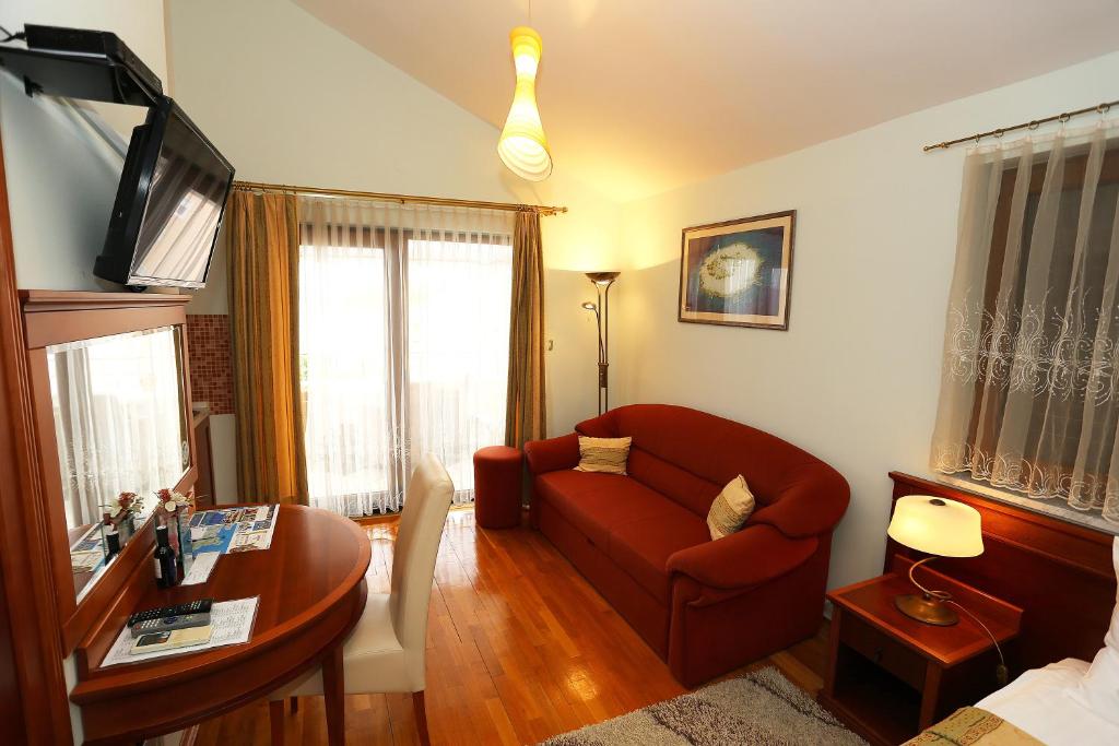 salon z czerwoną kanapą i stołem w obiekcie Villa Ivana B&B w mieście Zadar
