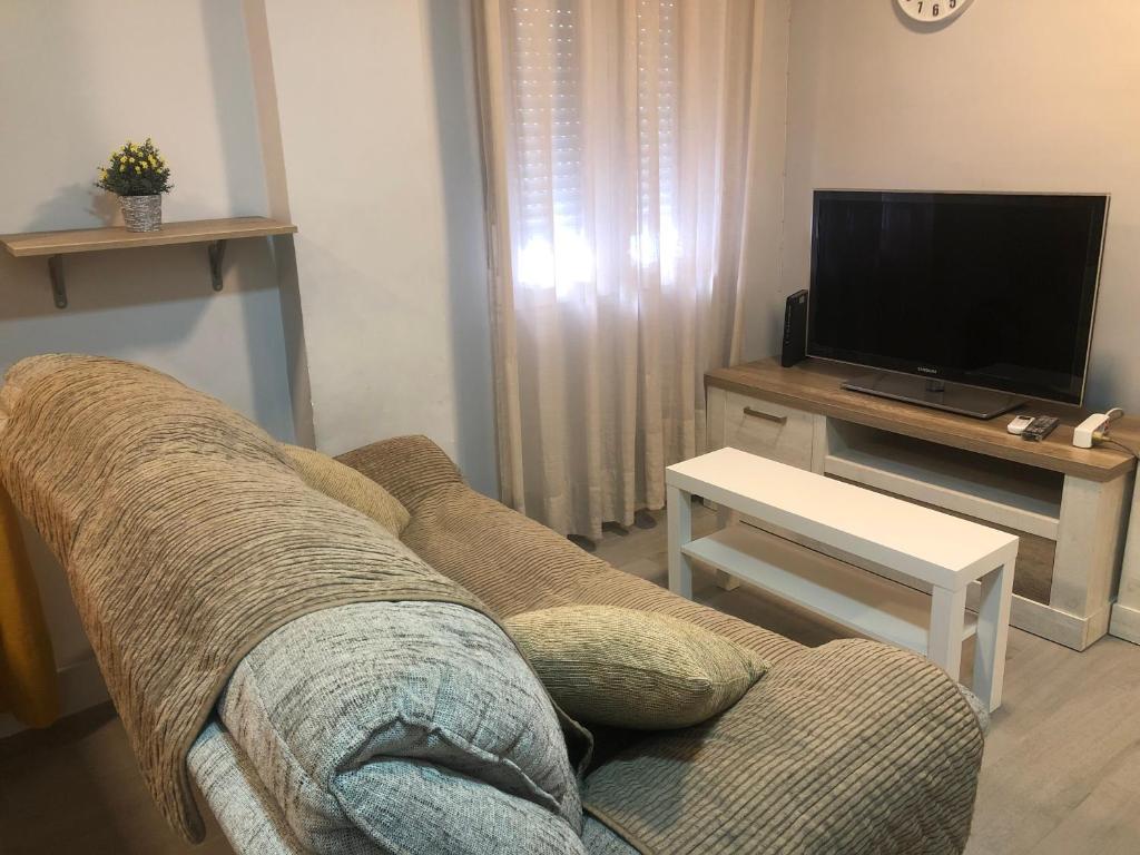 sala de estar con sofá y TV en Urban - Apartamento céntrico en Alcalá de Henares, en Alcalá de Henares